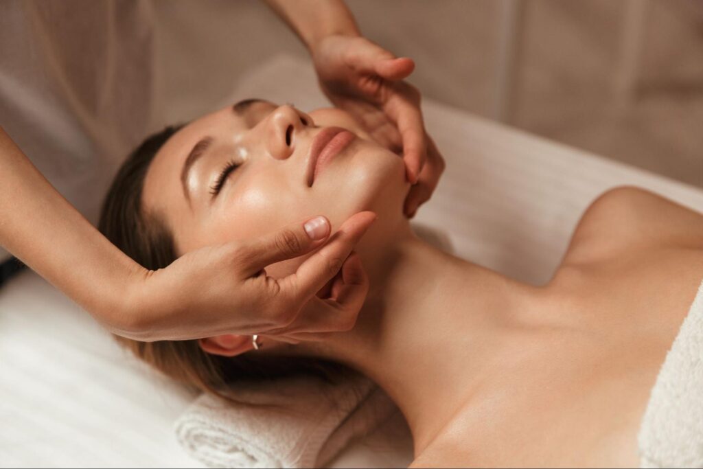 A woman receiving a relaxing facial massage as part of a spa treatment for glowing skin.